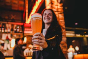 Moça jovem com copo de chopp patagonia na don antonio em bento Gonçalves